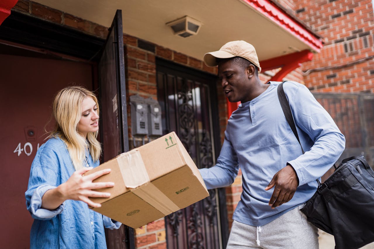 services-04 A delivery man handing a package to a woman at her doorstep, emphasizing delivery services.